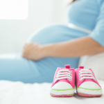 Femme enceinte avec souliers de bébé