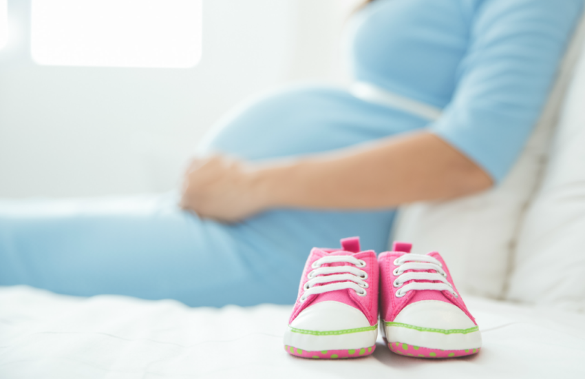 Femme enceinte avec souliers de bébé